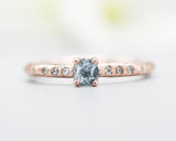 Round faceted blue topaz ring in prongs setting with tiny diamonds on 14k Rose gold texture design band