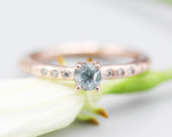 Round faceted blue topaz ring in prongs setting with tiny diamonds on 14k Rose gold texture design band