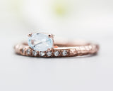 Oval faceted blue topaz ring in prongs setting with tiny diamonds on 14k Rose gold texture design band