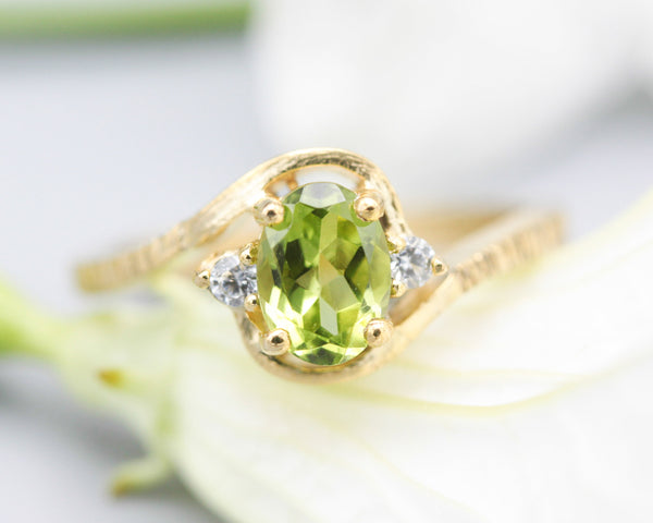 Oval Peridot ring and twin side set diamonds with 14k gold line texture band