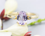 Oval faceted Amethyst ring with tiny round diamonds side set gems in prongs setting with 14k gold half round band
