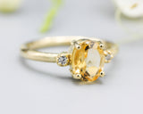 Oval faceted citrine ring with tiny round diamonds side set gems in prongs setting with 14k gold half round band
