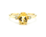 Oval faceted citrine ring with tiny round diamonds side set gems in prongs setting with 14k gold half round band