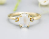 Oval cabochon Moonstone ring with tiny round diamonds side set gems in prongs setting with 14k gold half round band