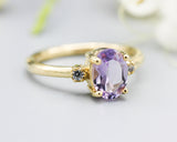 Oval faceted Amethyst ring with tiny round diamonds side set gems in prongs setting with 14k gold half round band