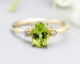 Oval faceted Peridot ring with tiny round diamonds side set gems in prongs setting with 14k gold half round band