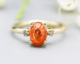 Oval cabochon Sunstone ring with tiny round diamonds side set gems in prongs setting with 14k gold half round band