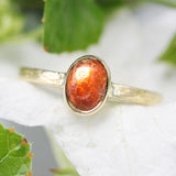 Oval cabochon sunstone ring in bezel setting with 18k gold texture band