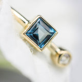 Princess cut London blue topaz ring and diamond in bezel setting with 18k gold high polished band