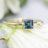 Princess cut London blue topaz ring and diamond in bezel setting with 18k gold high polished band