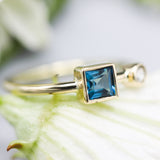 Princess cut London blue topaz ring and diamond in bezel setting with 18k gold high polished band