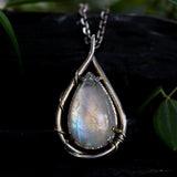 Rainbow Moonstone teardrop cabochon pendant necklace in silver bezel setting with silver vine design on a sterling silver chain