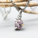 A vibrant rose pink spinel pendant necklace featuring a sterling silver bezel and prongs setting