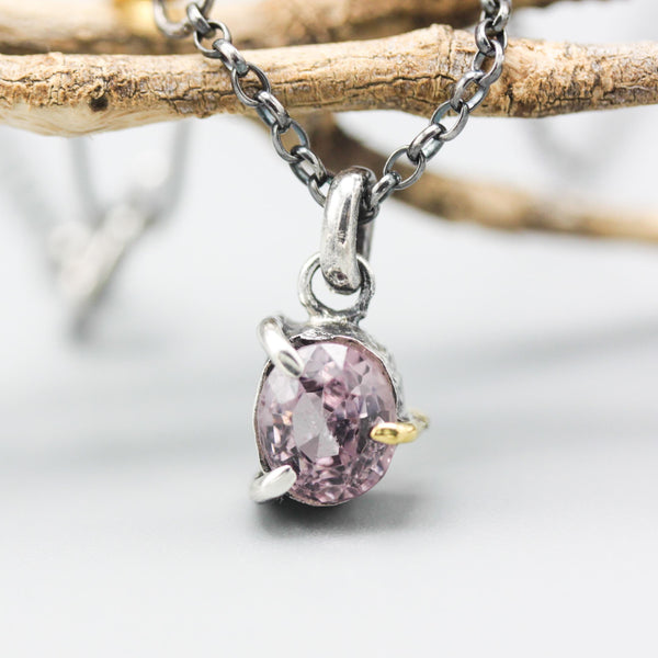 A vibrant rose pink spinel pendant necklace featuring a sterling silver bezel and prongs setting