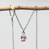 A vibrant rose pink spinel pendant necklace featuring a sterling silver bezel and prongs setting