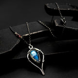 Moonstone teardrop cabochon pendant necklace in silver bezel and prongs setting with silver vine design on sterling silver chain