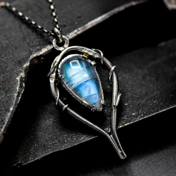 Moonstone teardrop cabochon pendant necklace in silver bezel and prongs setting with silver vine design on sterling silver chain