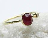 Angled view of the red center stone and clear accent on the textured band