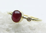 Oval red stone ring photographed on a pale stone surface