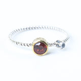 Round faceted garnet ring in brass bezel setting and cabochon tiny moonstone on the side with sterling silver twist band