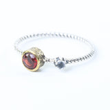 Round faceted garnet ring in brass bezel setting and cabochon tiny moonstone on the side with sterling silver twist band