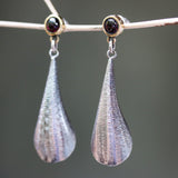 Silver leaf shape earrings with textured and tiny garnet in brass bezel setting on sterling silver post style - Metal Studio Jewelry