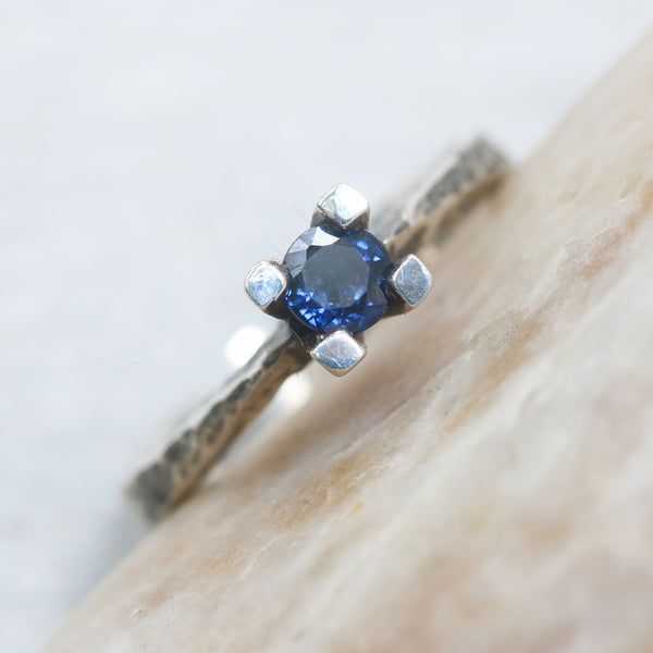Tiny round faceted blue sapphire ring in silver prongs setting with sterling silver hard texture oxidized band - Metal Studio Jewelry