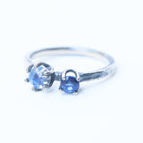 Moonstone ring in silver bezel and prongs setting and blue sapphire on the side with sterling silver hammer textured band