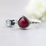 Teardrop faceted red ruby ring in silver bezel setting and tiny round moonstone with sterling silver twist design band
