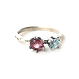 Round faceted pink spinel ring and blue topaz side set gems in prongs setting with sterling silver oxidized hammered textured band - Metal Studio Jewelry