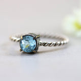 Round faceted blue topaz ring in silver bezel and brass prongs setting with sterling silver twist design band - Metal Studio Jewelry