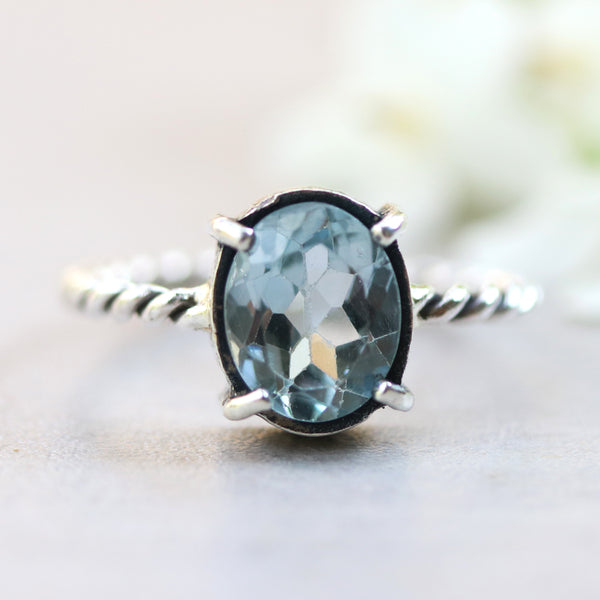 Oval faceted Swiss blue topaz ring in silver bezel and prongs setting on sterling silver oxidized twist design band - Metal Studio Jewelry