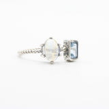 Oval moonstone ring in silver prongs setting and tiny blue topaz on the side - Metal Studio Jewelry