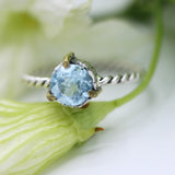Round faceted Swiss blue topaz ring in silver bezel and brass prongs setting on sterling silver twist design band - Metal Studio Jewelry