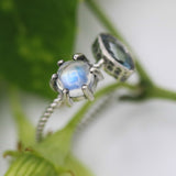 Marquis faceted Swiss blue topaz ring in silver bezel setting and moonstone on the side with sterling silver twist design band - Metal Studio Jewelry