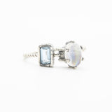 Oval moonstone ring in silver prongs setting and tiny blue topaz on the side - Metal Studio Jewelry