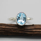 Oval blue topaz ring in silver bezel setting with sterling silver hammered texture band - Metal Studio Jewelry