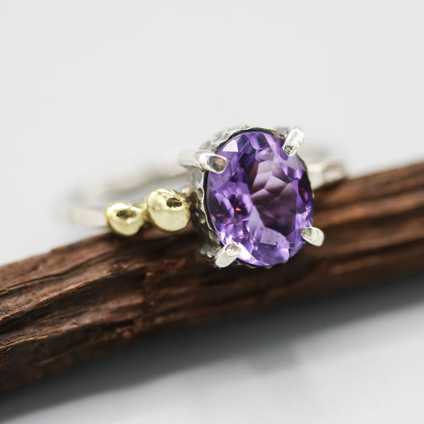 Oval faceted Amethyst ring in silver bezel and prongs setting and brass beads on the side with sterling silver texture band - Metal Studio Jewelry