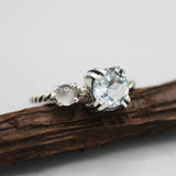 Round faceted blue topaz ring in silverr bezel and double prongs setting and moonstone on the side - Metal Studio Jewelry