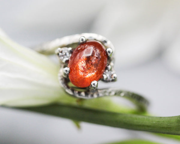 Cabochon sunstone ring with diamonds side set gems in prongs setting with sterling silver texture band