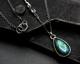 Labradorite pendant necklace in silver bezel setting with oval blue topaz secondary