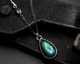 Labradorite pendant necklace in silver bezel setting with oval blue topaz secondary