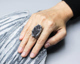 Large black Brazilian raw druzy ring in silver bezel and prongs setting with silver skeleton band