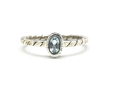 Tiny oval faceted blue topaz ring in silver bezel setting on sterling silver twist design band