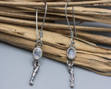 Oval moonstone earrings in silver bezel setting with silver sticks and hooks style on the top