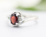 Oval Garnet ring in texture sterling silver band and twin side set labradorite gemstone