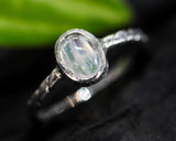 Oval cabochon Moonstone ring in silver bezel setting with sterling silver twist design band