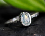 Oval cabochon Moonstone ring in silver bezel setting with sterling silver twist design band