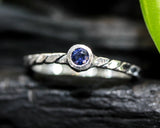 Dainty silver band with round faceted blue sapphire gemstone in bezel setting