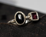 Oval black star diopside ring and garnet with sterling silver oxidized texture band